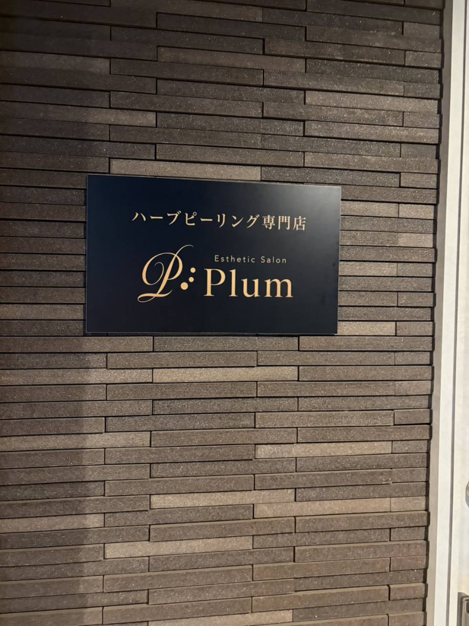 入口横にあるPLUMの看板